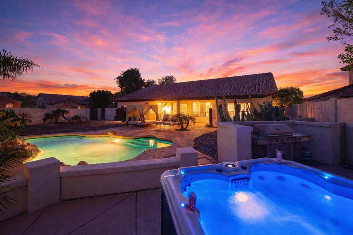 Backyard featuring pool, hot tub, bbq grill, outdoor cabana bed, sun loungers, and outside dining area.