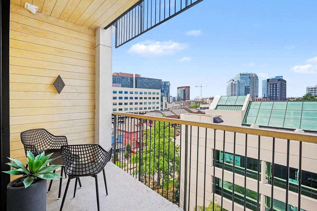 Private balcony with outdoor seating and views of downtown.