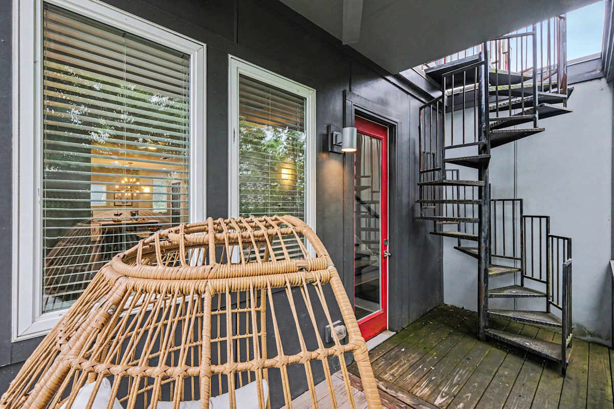 Private balcony with an outdoor chair, with a staircase leading to the rooftop deck. (2nd Floor)