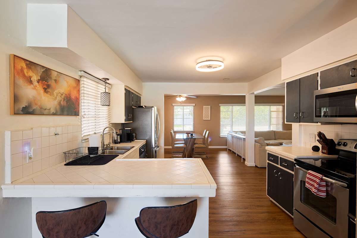 Cooks can spread out at the tile counters in the kitchen, stainless steel appliances and a pass-through bar keeping the space connected to the dining and living areas beyond.