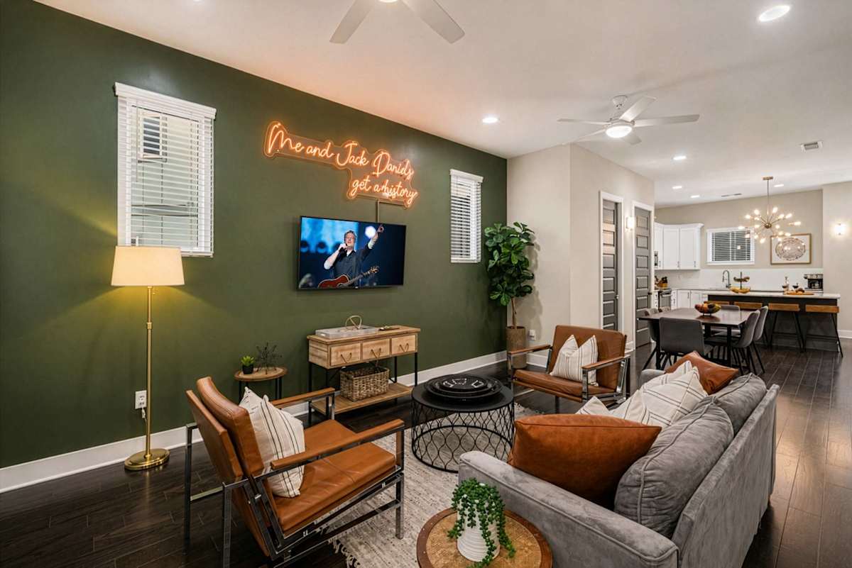 Bright open-floor living space featuring comfortable furnishings, a smart flat-screen TV, and private access to a balcony. (2nd Floor)