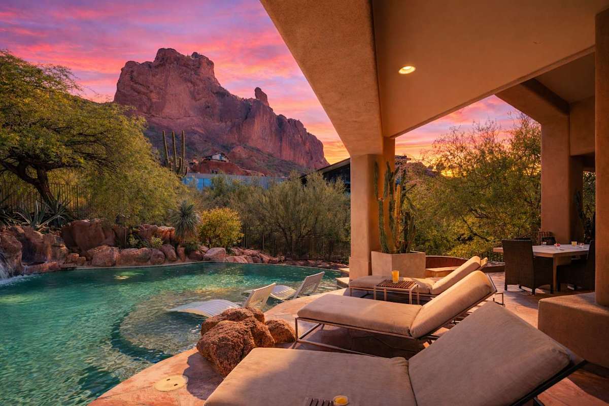Resort-style backyard with a sparkling pool, waterslide, hot tub, sun loungers, private patio a beautiful view of the scenery.