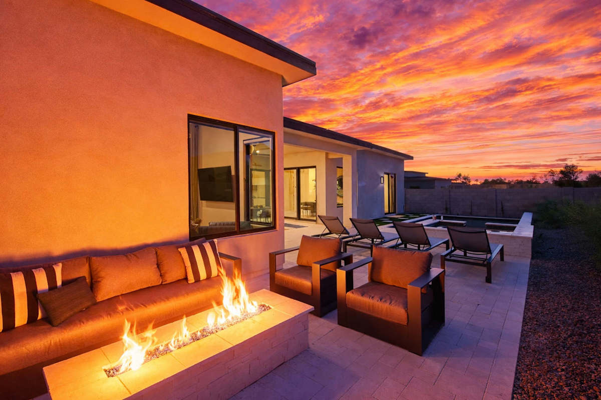 Resort-like backyard featuring a built-in BBQ, a covered patio offering outdoor dining, a firepit with outdoor furnishings complete with a sparkling heated pool & spa.