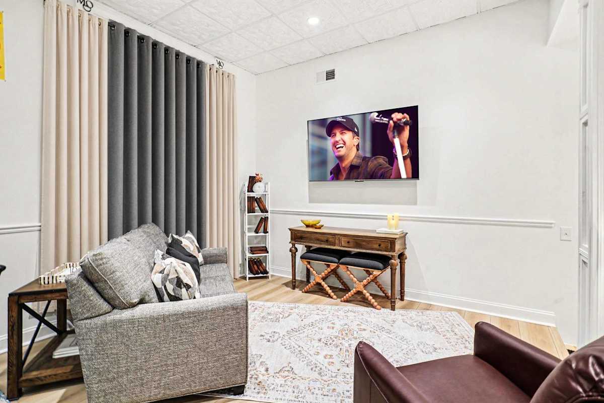 Unwind under in this second lounge area, complete with a comfy sofa, leather armchairs, and a smart TV, just steps from the dining table for the perfect entertaining flow.