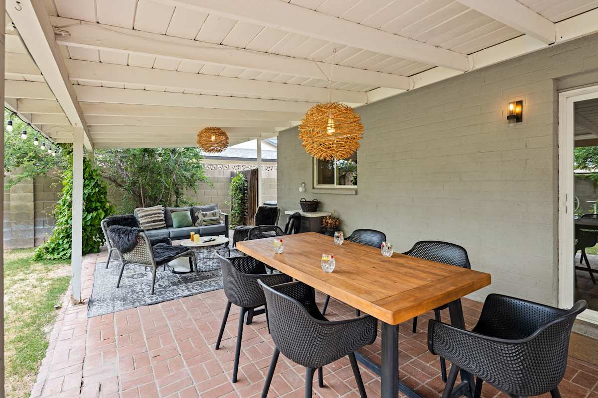 Private backyard featuring a covered patio with an outdoor lounge area and dining area, BBQ grill, and outdoor seating.