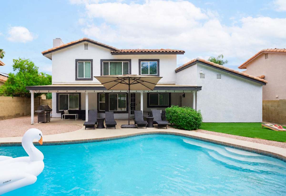 Spacious backyard with a private pool, sun loungers, BBQ, covered patio, outdoor dining, seating area, and corn hole!