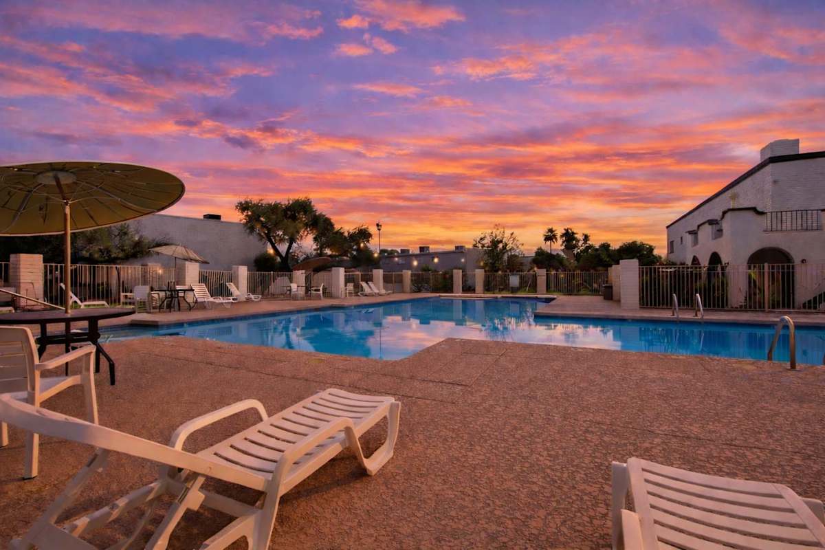 Communal Area: Sparkling blue pool with lounge chairs and outdoor seating.