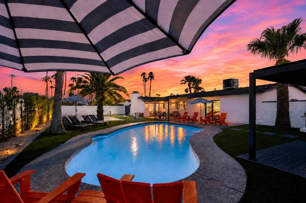 Private pool surrounded by poolside loungers, umbrellas, and multiple shaded seating areas.