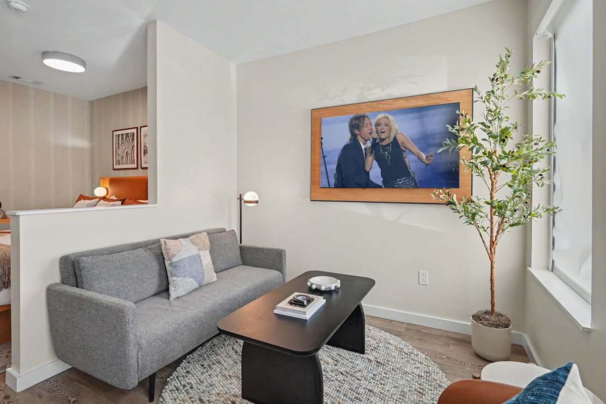 Living Area with plush seating, a Smart TV, and an open-concept layout that seamlessly connects to the dining area and kitchen.