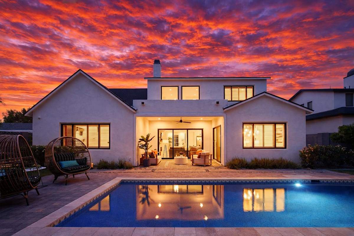 Private backyard with a sparkling pool and a covered patio with outdoor seating.