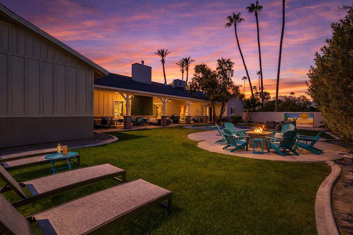 Backyard with covered patio, multiple seating areas, ping pong table, yard games, BBQ grill, fire pit, sun loungers, and sparkling pool.