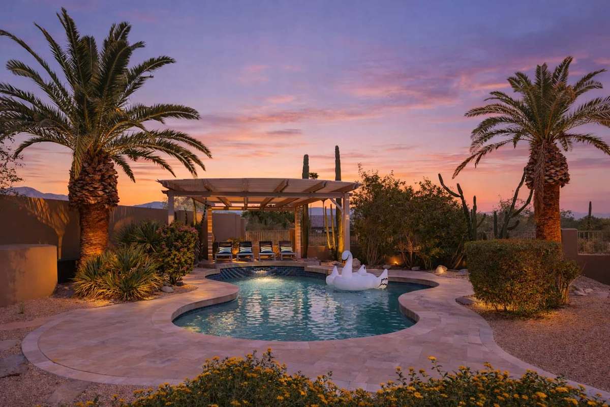 Resort-style backyard with a sparkling pool, gazebo with sun loungers, and covered patio with an outdoor dining table for 8.