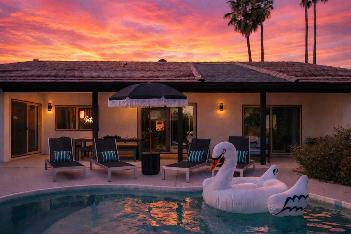 Outdoor oasis featuring a sparkling pool, lounge chairs, pergola with a covered dining table, outdoor lounge areas, and an additional dining area.