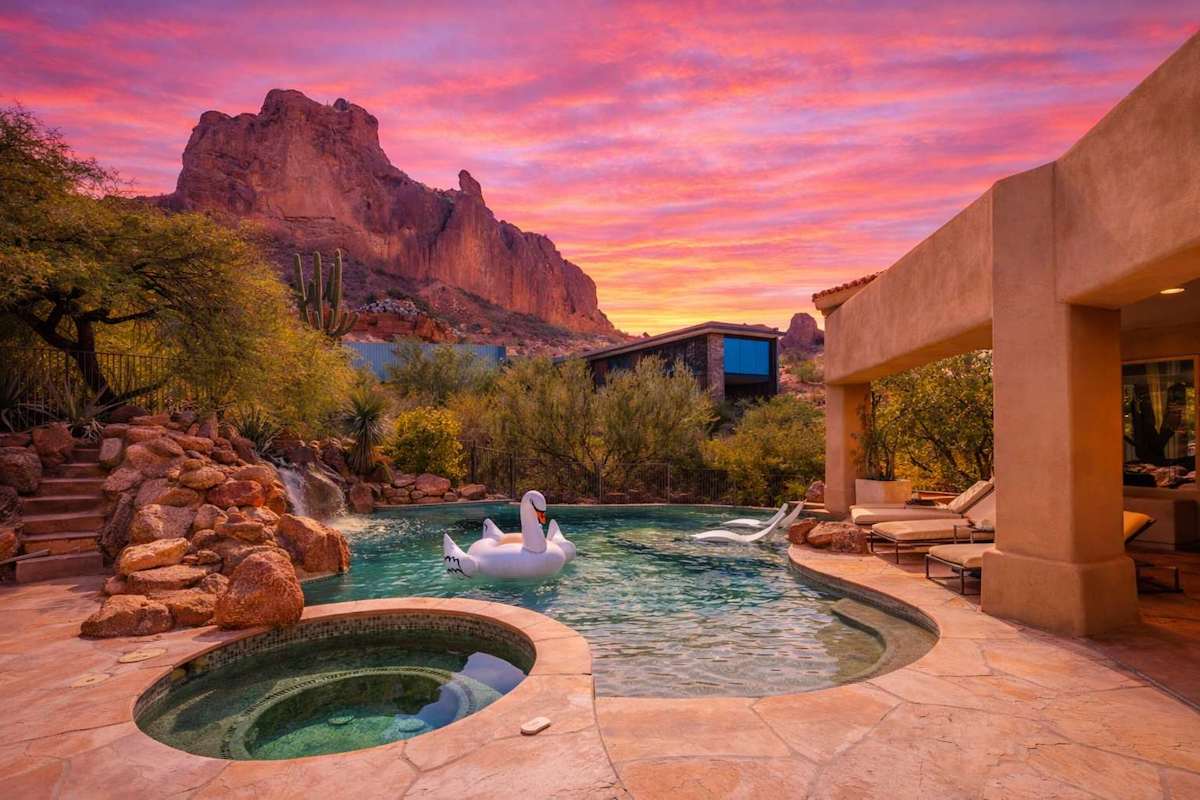 Resort-style backyard with a sparkling pool, waterslide, hot tub, sun loungers, private patio a beautiful view of the scenery.