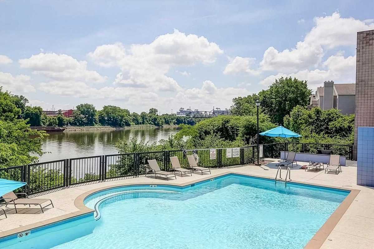 Community pool overlooking the Cumberland River, complete with lounge seating and outdoor umbrellas. The perfect place to cool off, soak up the sun, or unwind after a day exploring Nashville.