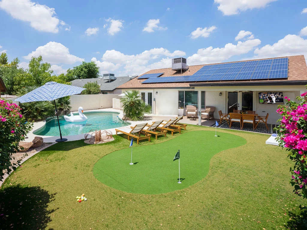 Backyard featuring pool, putting green, and outside dining area.