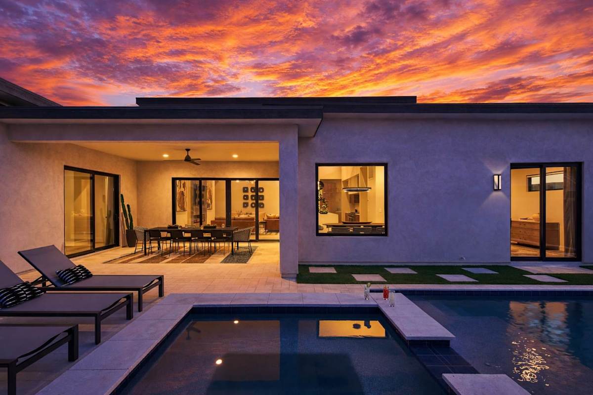 Resort-like backyard featuring a built-in BBQ, a covered patio offering outdoor dining, a firepit with outdoor furnishings complete with a sparkling heated pool & spa.