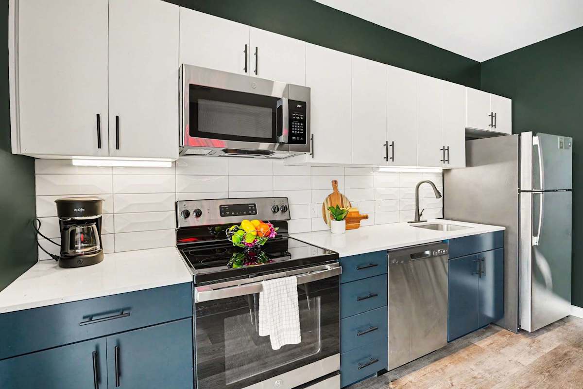 Fully equipped kitchen with stainless steel appliances, electric stove top, microwave, dishwasher, oven, and full size fridge.