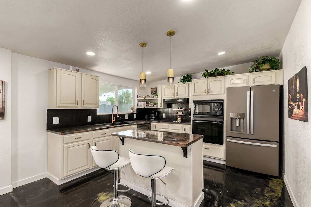 Whip up a family meal in the fully equipped kitchen, complete with sleek black countertops and a two-seat breakfast bar for casual mornings.