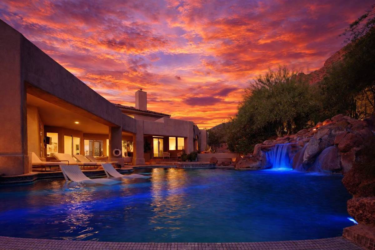 Resort-style backyard with a sparkling pool, waterslide, hot tub, sun loungers, private patio a beautiful view of the scenery.